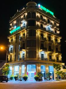 a large building with a green sign on it at Blue Ocean Hotel Phan Thiết - by BAY LUXURY in Ấp Bình Hưng