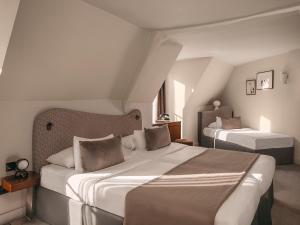 a bedroom with two beds in a room at Hôtel Belloy in Paris