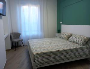a small bedroom with a bed and a chair at Palazzo Schirù in Troia