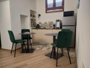 a kitchen with green chairs and a table and a refrigerator at Palazzo Schirù in Troia