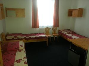 弗沃茨瓦韦克Arsenał Kwatery的有两张床、一张桌子和几把椅子的房间