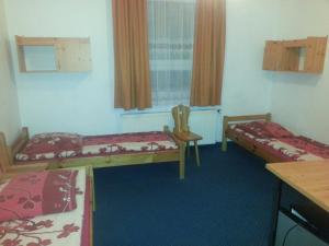 Zimmer mit 2 Betten, einem Tisch und einem Schreibtisch in der Unterkunft Arsenał Kwatery in Włocławek