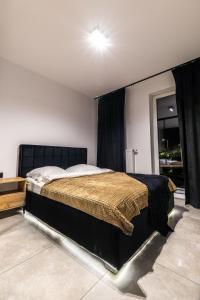 een slaapkamer met een groot bed met een zwart hoofdeinde bij Exclusive place with underground parking and terrace in Oświęcim