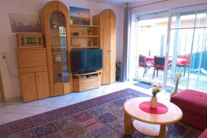 a living room with a tv and a table at Ferienwohnung Claudia in Norden