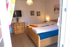 a bedroom with a bed and a dresser with a television at Ferienwohnung Claudia in Norden