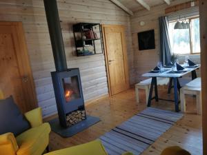 a living room with a fireplace in a cabin at Stuga Mörtbäcken in Koppom