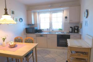 a kitchen with a sink and a table with chairs at Ferienwohnung Claudia in Norden