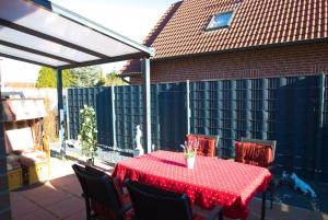a table with a red table cloth on a patio at Ferienwohnung Claudia in Norden