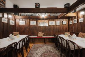 a dining room with tables and chairs and wooden walls at Penzion Farma U Mauritzů, Stožec 42, Stožec, 38444, Czech Republic in Stožec