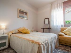 a bedroom with a bed and a chair at Preciosa casa con un enorme jardín in El Vendrell
