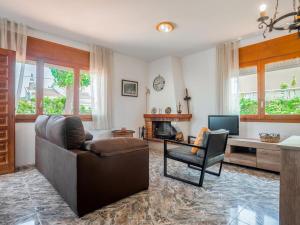 a living room with a couch and a chair and a television at Preciosa casa con un enorme jardín in El Vendrell