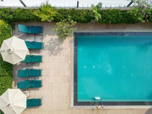 an overhead view of a swimming pool with chairs and umbrellas at Kantary House Hotel, Bangkok in Bangkok