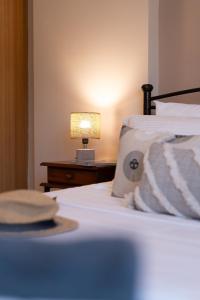 een slaapkamer met een bed met een lamp op een nachtkastje bij The Mirror Apartment in Mytilini