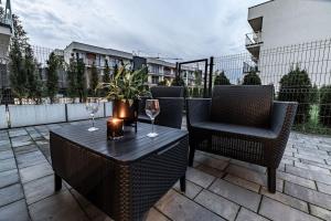 een tafel en stoelen met wijnglazen op een patio bij Exclusive place with underground parking and terrace in Oświęcim