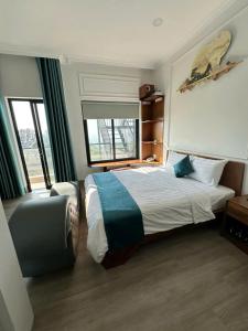 a hotel room with a bed and a chair at Blue Ocean Hotel Phan Thiết - by BAY LUXURY in Ấp Bình Hưng