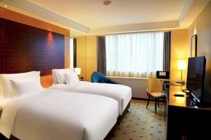 a hotel room with two beds and a television at Radisson Collection Hyland Shanghai in Shanghai
