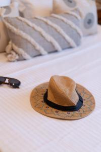 een hoed en zonnebril op een bed bij The Mirror Apartment in Mytilini