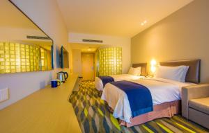 a hotel room with two beds and a couch at Holiday Inn Express Changzhou Lanling, an IHG Hotel in Changzhou