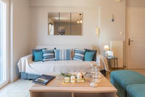 sala de estar con cama con almohadas azules en The Mirror Apartment, en Mytilini
