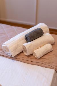 een houten snijplank met drie handdoeken op een bed bij The Mirror Apartment in Mytilini