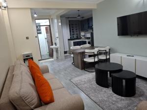 a living room with a couch and a table and a kitchen at polma suites in Kisumu