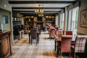 a restaurant with tables and chairs in a room at The Derwent Arms in Edmondbyers