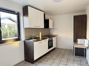 a kitchen with white cabinets and a sink and a window at House in Bergisch Gladbach in Bergisch Gladbach