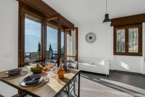 jadalnia ze stołem i zegarem na ścianie w obiekcie Casa dei Nonni Apartments w Tremosine Sul Garda
