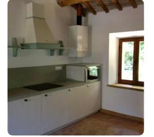 a kitchen with white cabinets and a window at Villa Boccolini Appartamento in Sirolo