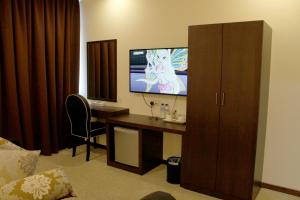 a room with a desk with a computer and a tv at The View Hotel in Segamat