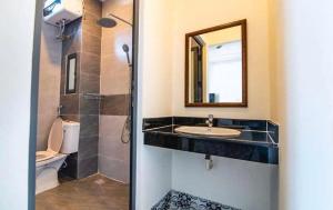 ホーチミン・シティにあるBeautifull luxury homeの洗面台、鏡、トイレ付きのバスルーム