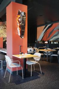 a restaurant with tables and chairs and a painting at Hotel & Spa des Gorges du Verdon in La Palud sur Verdon