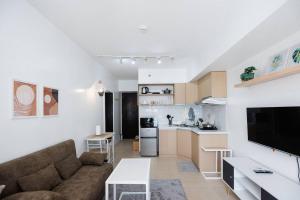 宿务Cozy Condo at Avida Tower 4, IT Park Cebu的客厅里有一张沙发和一个厨房