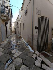 a stone alley with a gate on the side of a building at B&B Claustro Mirti in Altamura