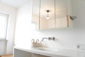 Un baño blanco con lavabo y espejo. en Stylish Country House Happiness, en Geislingen 18 fotos más