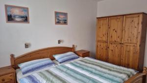 une chambre avec un lit et une armoire en bois dans l'établissement Ferienhaus Nr 91, Kategorie Komfort, Feriendorf Hochbergle, Allgäu, à Karlsebene
