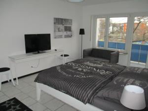 ein Schlafzimmer mit Bett, Schreibtisch und Fernseher in der Unterkunft Kleine Wohlfühloase 2.0 in Heidelberg