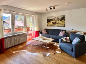 a living room with a blue couch and a table at BERGFEX Jägersberg mit Sommer-Bergbahnticket in Oberstdorf +12 photos