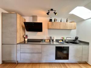 a kitchen with stainless steel appliances and a tv at BERGFEX Jägersberg mit Sommer-Bergbahnticket in Oberstdorf