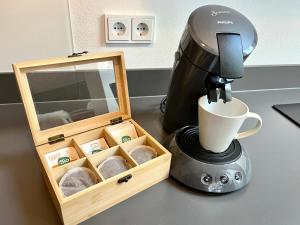 a coffee maker next to a box of muffins at BERGFEX Jägersberg mit Sommer-Bergbahnticket in Oberstdorf