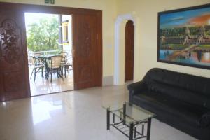 a living room with a black couch and a table at The Magic Sponge in Kampot