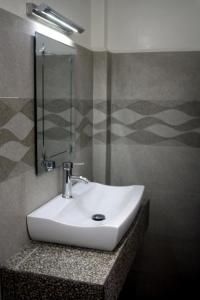 a bathroom with a white sink and a shower at The Magic Sponge in Kampot +18 photos
