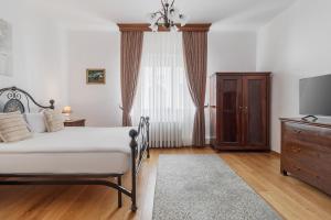a bedroom with a bed and a dresser with a television at Casa Bella in Oradea