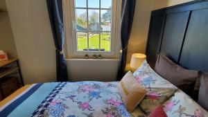 Un dormitorio con una cama con ventana. en Vieille Fermette BnB chambre prive, en Waben