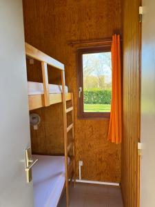 a small room with two bunk beds and a window at Camping de Prémery Les prés de la ville in Prémery +7 photos