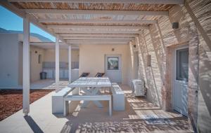 a picnic table on the patio of a house at Villa Aqua Blue 1 - Etheras properties in Diakofti
