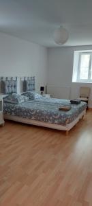 a large bed in a room with a wooden floor at Eugénie in Saint-Quentin-de-Chalais