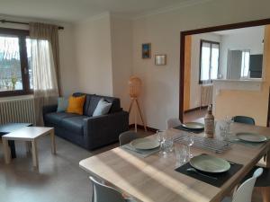 a living room with a table and a couch at Appartement dans maison au calme in Oyonnax