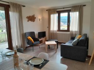 a living room with a couch and a table at Appartement dans maison au calme in Oyonnax
