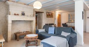 a living room with a blue couch and a fireplace at Eugénie in Saint-Quentin-de-Chalais